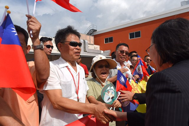 President Tsai shakes hands with Taiwanese expatriates in Belize, who welcome her at Philip S.W. Goldson International Airport.