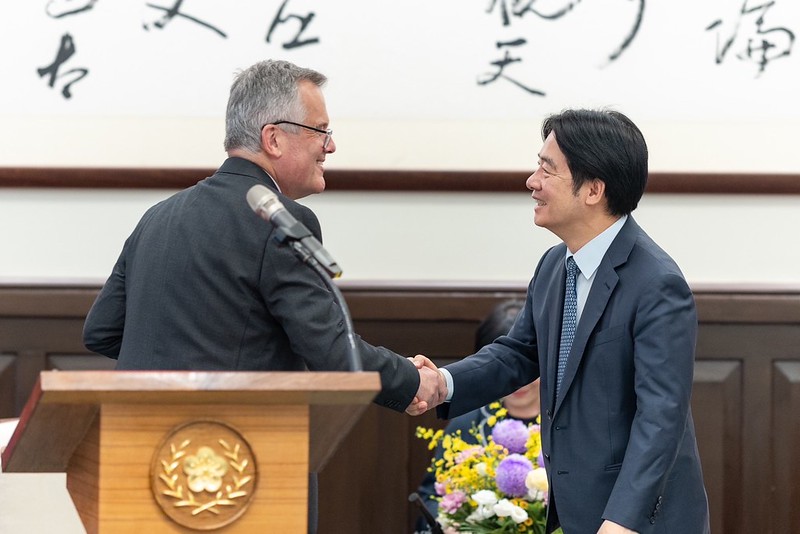 President Lai Ching-te shakes hands with British Office Taipei Representative John Dennis.