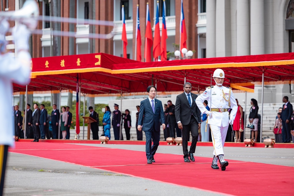 The President escorts the visitor past the band and the honor guard.