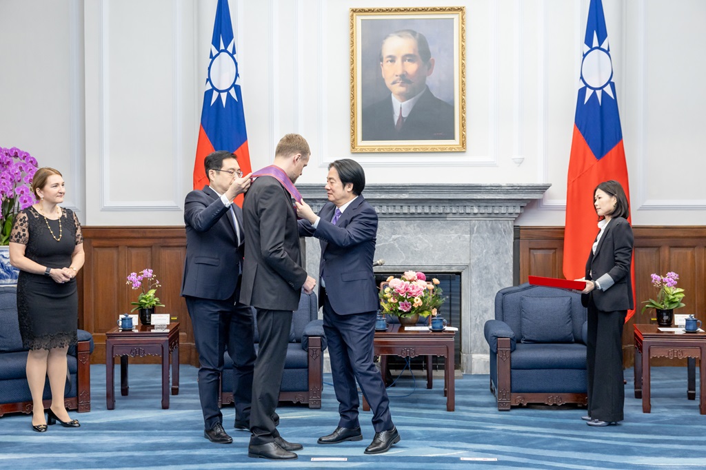 The President is assisted by the Director-General of the Office of the President's Third Bureau to decorate the recipient with a medal.