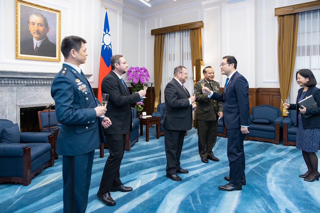 The Secretary-General to the President, the Minister of Foreign Affairs, and the Director-General of the Third Bureau offer their congratulations to the ambassador with a champagne toast and then take photos together